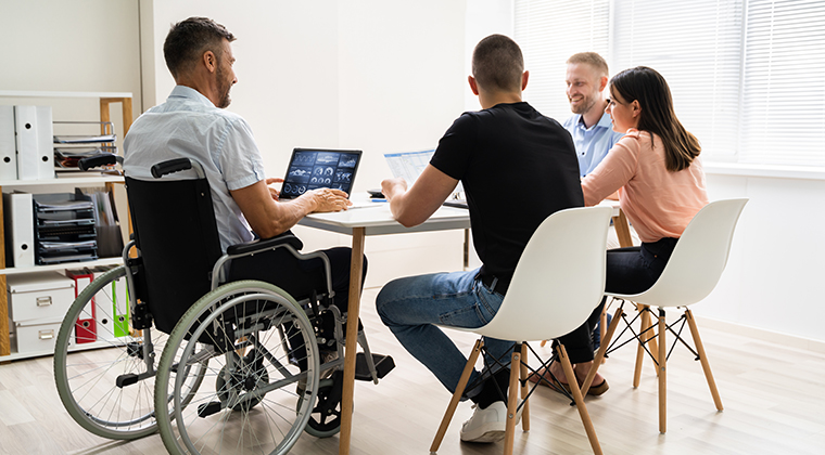 A group of professionals sit around a table and discuss strategies for launching their new SaaS product. 