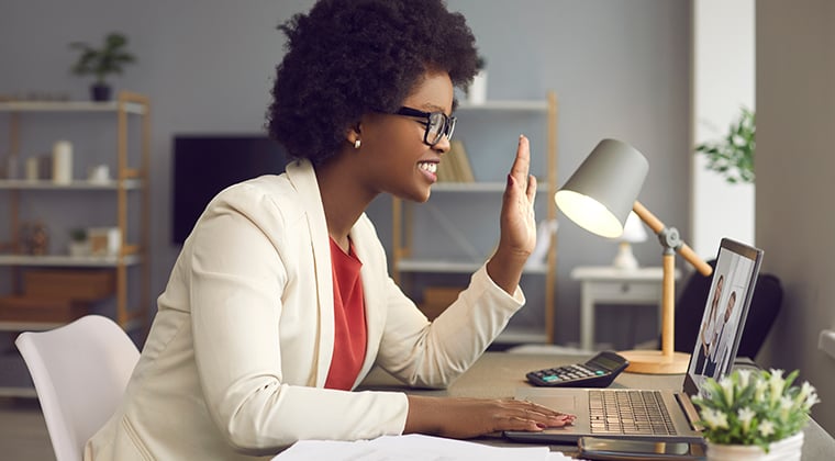 A professional sits at her desk and discusses the sales and marketing strategy for her company's new product via a Zoom call. 