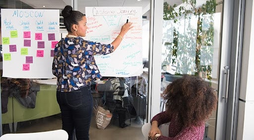 A tech company employee stands at a white board and figures out new ways to innovate.