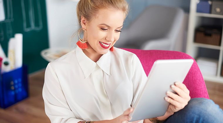 A woman uses a tablet to search for jobs