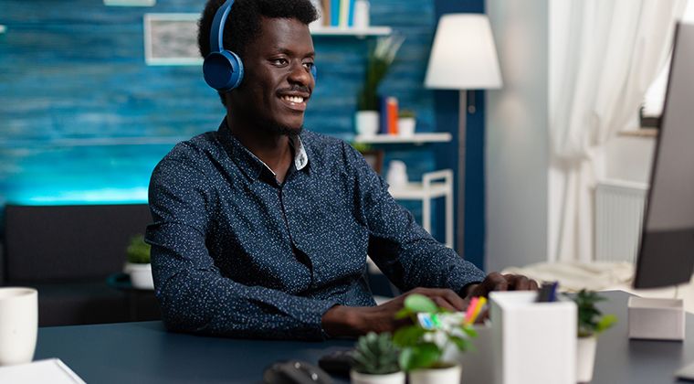 A modern-day job seeker smiles after learning he was hired for a job. 