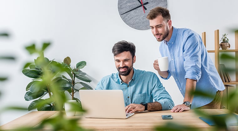 Two coworkers read the 2023 Aptitude Research publishes an annual Talent Acquisition Buyer’s Guide.