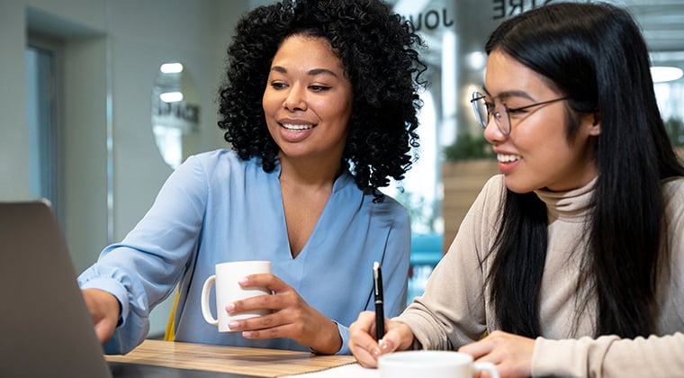 Two women professionals working on a laptop