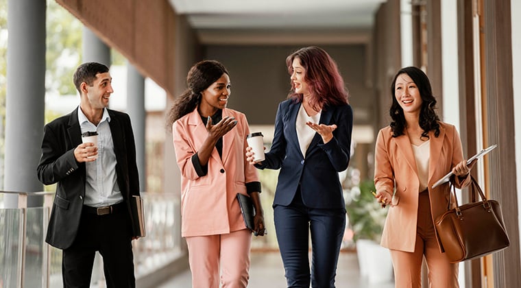 Four conference attendees talking about HR technology