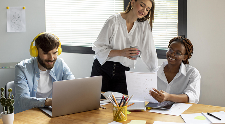 Three colleagues prepare to conduct job interviews in a conference room. 