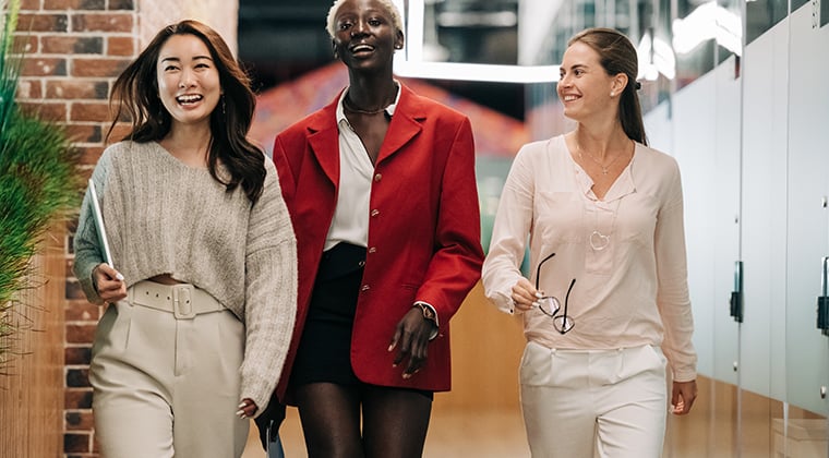 Three employees celebrate a company milestone.