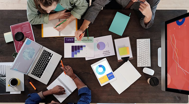 Onboarding documents lay on a workplace table. 
