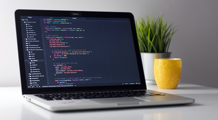 Laptop on desk displaying code