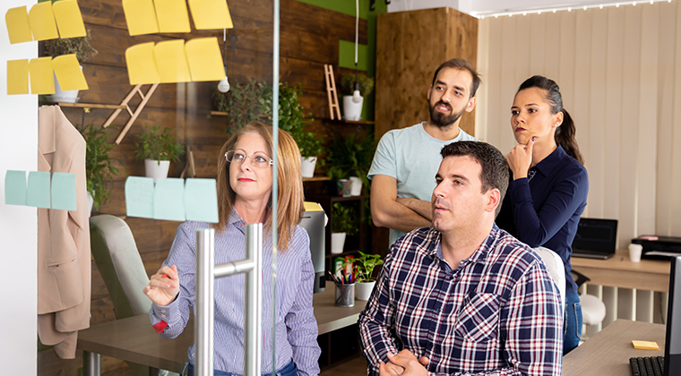 Four co-workers brainstorm with post-it notes