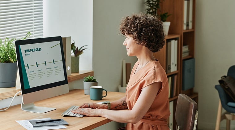 Employee works on a computer to build hr workflow processes